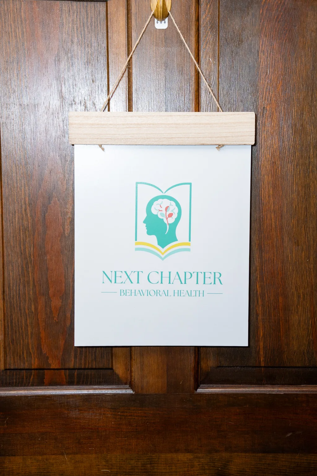 The Next Chapter Behavioral Health logo sign hanging on their office door